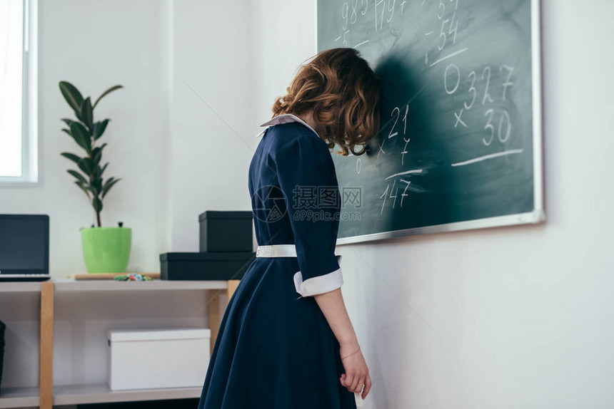 站在黑板前的悲伤女学生图片