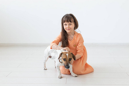 儿童与宠物概念穿橙色裙子的小女孩和杰克罗图片