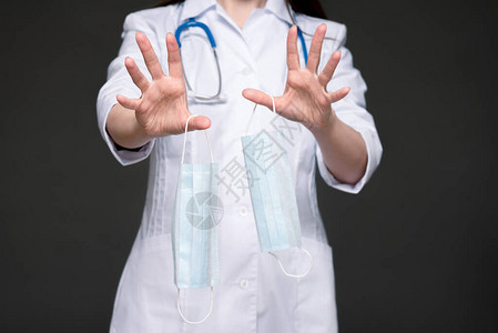 手握医疗面罩的医生在紧闭的手上表现出了停图片