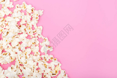 盐渍的粉红色背景上的爆米花电影或电视背景架顶视设计图片