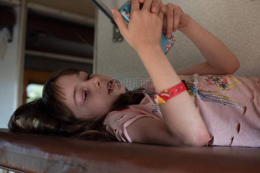可爱的女孩躺在火车的顶层架子上暑假和旅游概念火车上的女孩一个8或9岁的女孩乘坐火车女孩在智图片