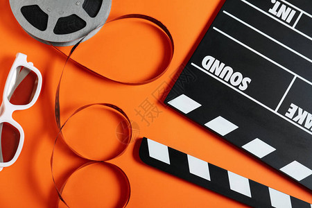 橙色背景上带有隔板的平躺构图电影制作图片