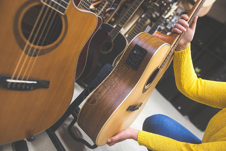 音乐器概念女选择在乐器店购买新吉他商店图片