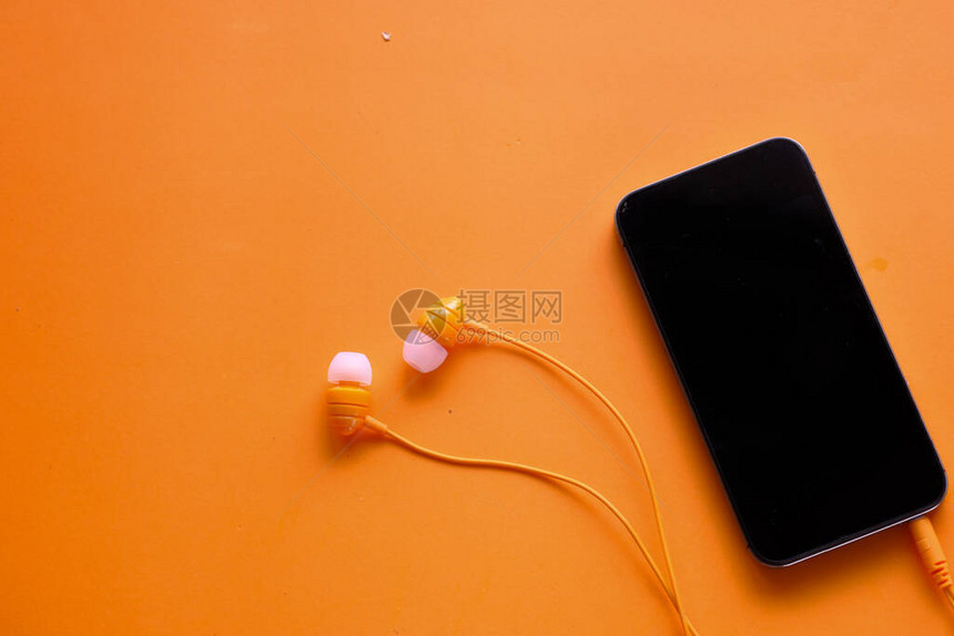 智能手机和耳机在橙色背图片