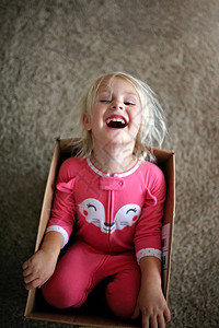 一个快乐的小女孩正在笑因为她在家里的图片