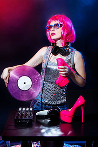 年轻的DJ女人手里拿着乙烯基和粉红色的鞋子迷人的女孩图片