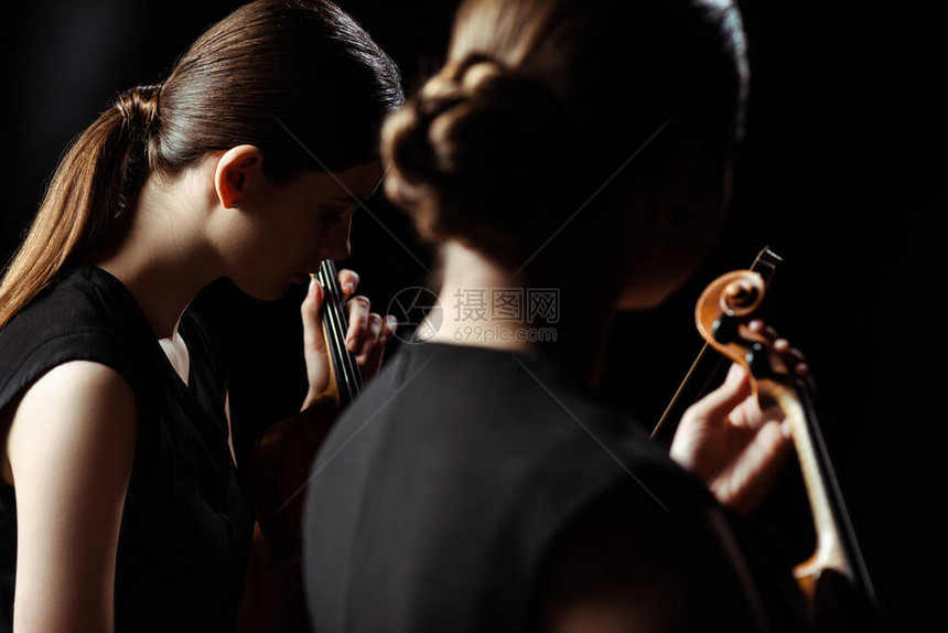 专业音乐家在黑暗舞台的小提琴上图片