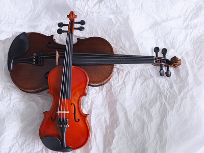 较小的提琴戴上较大的小提琴背景图片