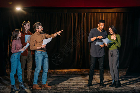 多民族青年演员和女演员在舞台上与成熟的戏剧导演一背景图片
