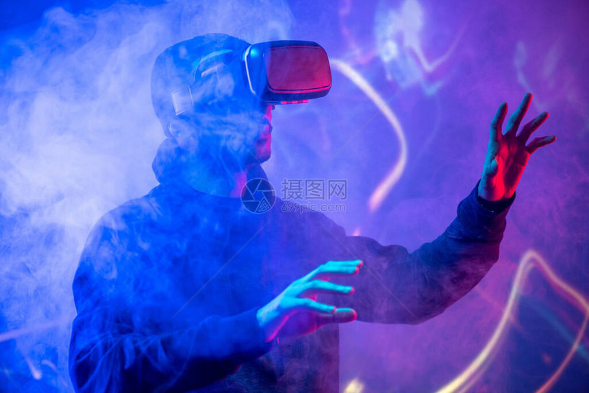 阿拉伯青年男子使用虚拟现实设备在烟熏V图片