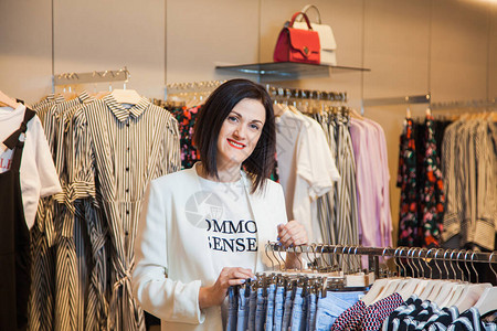 年轻女子在服装店选择牛仔裤休闲装图片