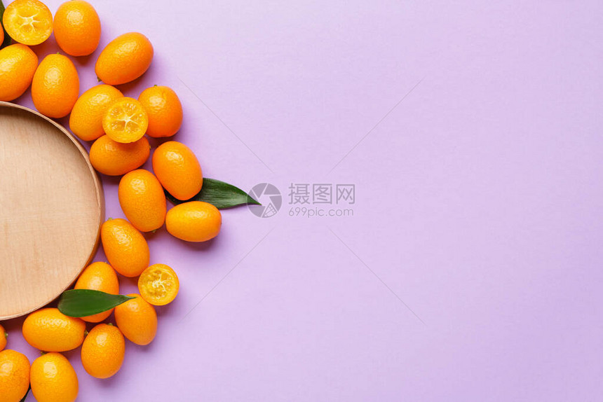 颜色背景上带盘子的美味金橘果图片