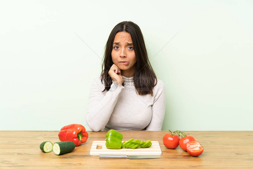 有蔬菜的青褐色年轻女人怀疑和混淆脸图片