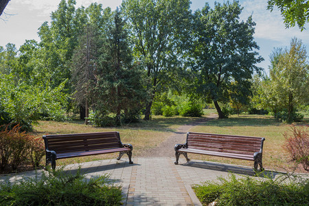 公园花坛附近的两张长椅图片