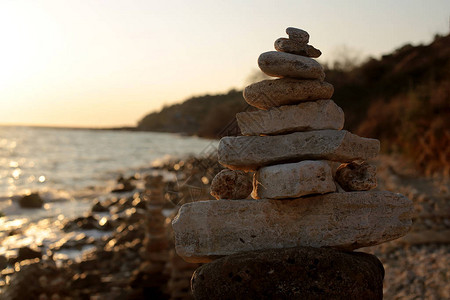 海边日落时的石头平衡黎高清图片