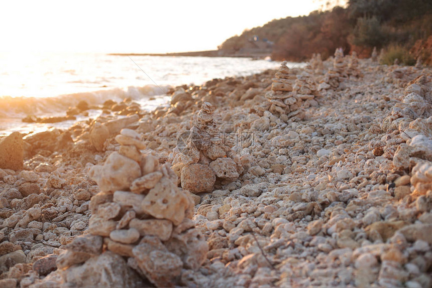 海边日落时的石头平衡黎图片