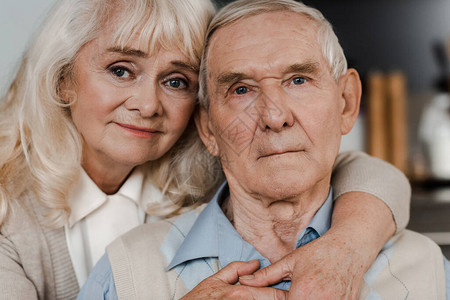伤心的老年妻子和丈夫抱坐在图片