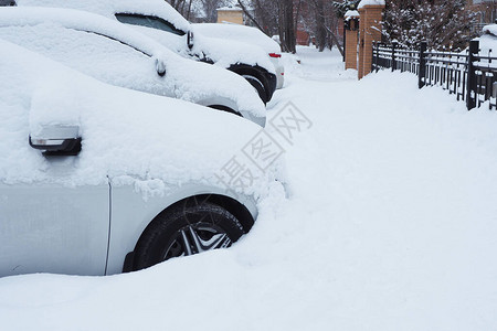 下雪后停放有雪覆盖汽车道路图片