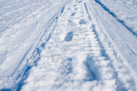雪中人脚印在雪地车轨背景的雪上人脚图片