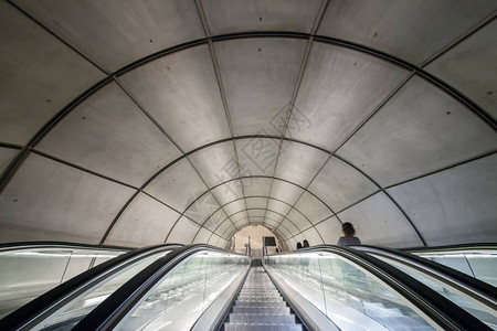 通往带有弧形屋顶的地铁站的自动扶梯图片