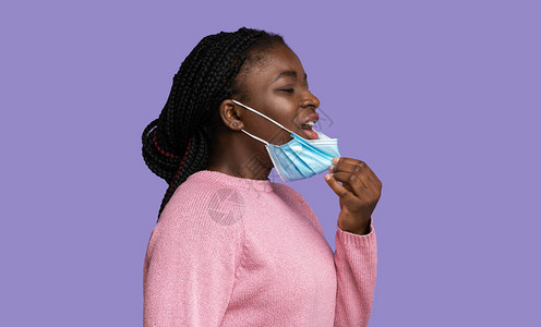 年轻的黑人妇女摘下防护医用口罩图片