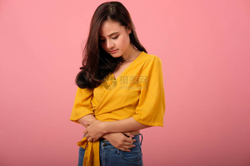 妇女触摸胃部和胃痛因月经期抽搐而疼痛的妇女图片
