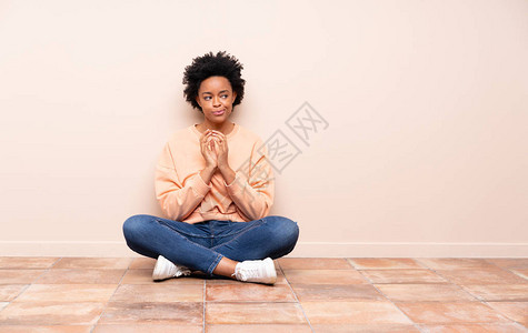 坐在地板上坐着的非洲美女人在图片