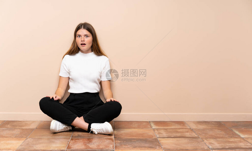 乌克兰少女坐在地板上面部表情令人惊讶图片