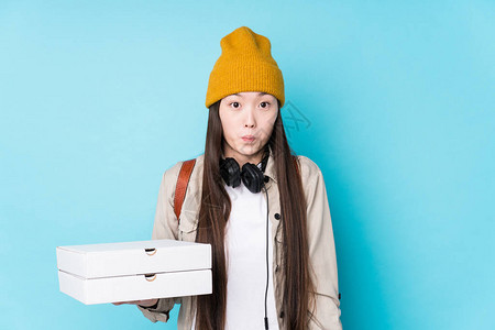 年轻女人拿着披萨肩膀被孤立眼睛图片