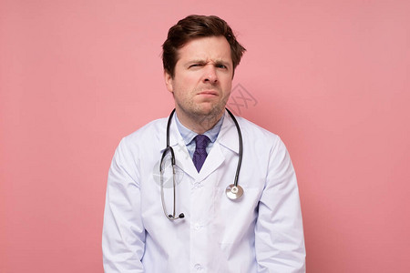 疑惑的男医生对粉红色墙上的图片
