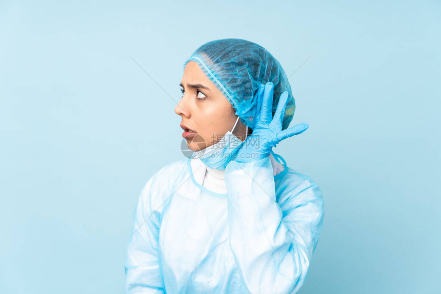 穿蓝制服的年轻外科医生印度女青年在耳朵上用图片