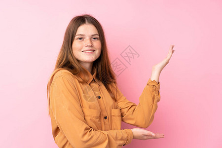 身穿孤立的粉红背景乌克兰少女将双手伸到一边图片