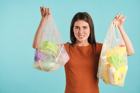 情绪激动的女孩紧张地拿着装有塑料垃圾的生态袋图片