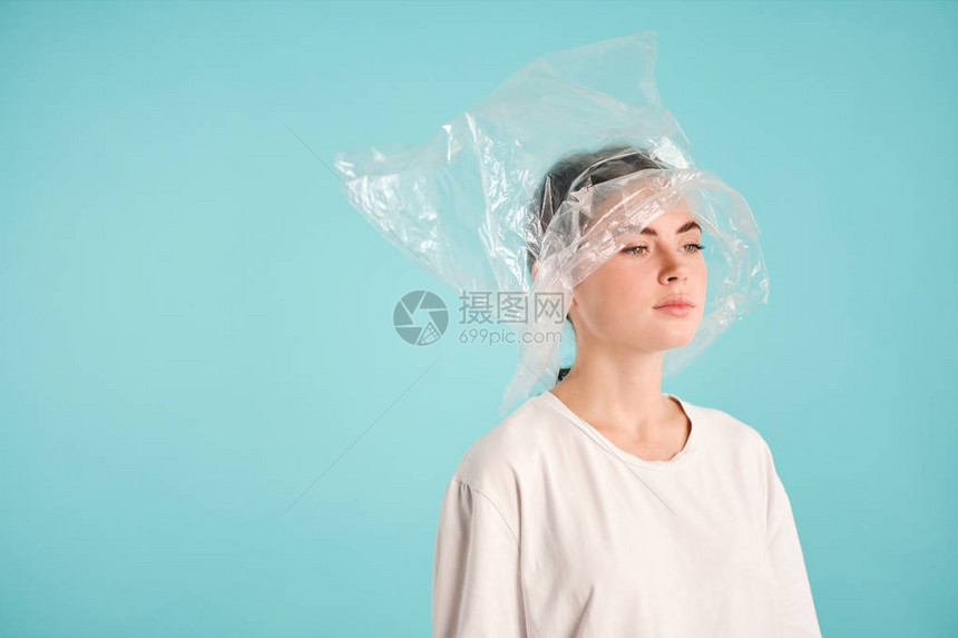 头顶上塑料袋的不开心女孩的侧面景色故意在色彩多的背图片