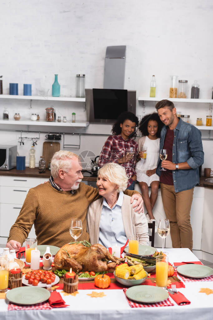 老年男子在与多族裔家庭庆祝感恩节时图片