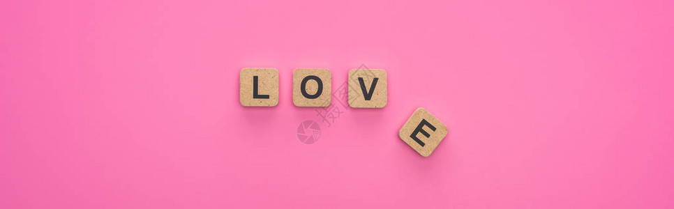 粉红色背景的木立方体上方的爱情文图片