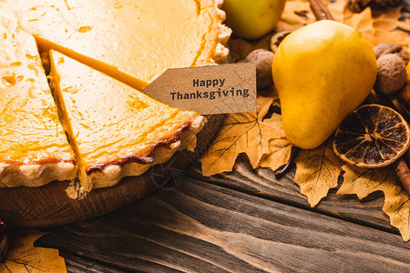 近距离观看秋天装饰和南瓜馅饼在棕木背景上带感恩卡背景图片