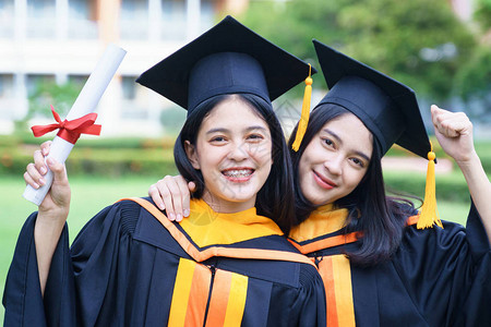 年轻的亚洲女子大学毕业生在毕业典礼上获得大学位证书后图片