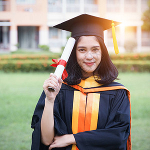 年轻的亚洲女子大学毕业生在毕业典礼上获得大学位证书后图片