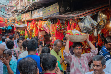 年轻人带着Laxmi女神和Ganesh勋爵的彩色粘土偶像图片