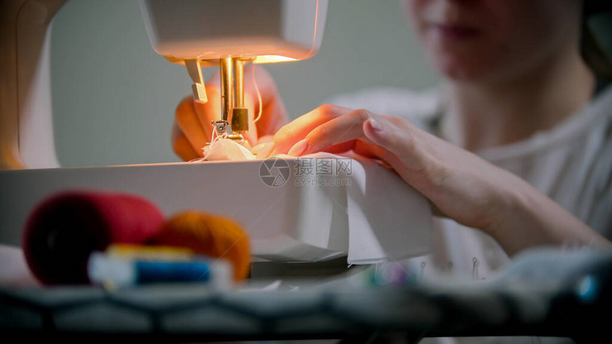 年轻女设计师用缝纫机缝上可重图片