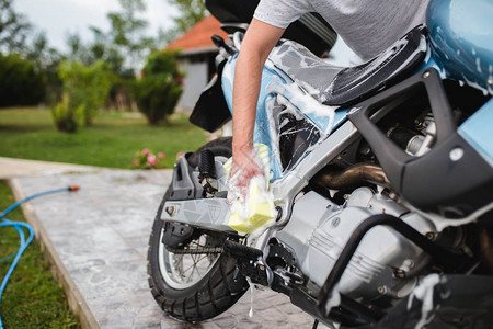 男子清洁摩托车摩托车细节或代客概念图片