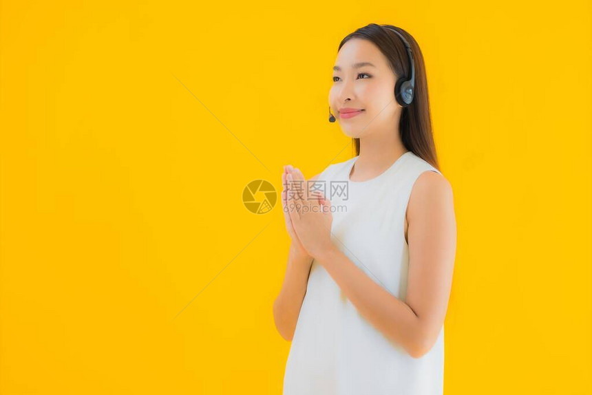 肖像美丽的年轻亚洲女呼叫中心在黄色孤立背图片