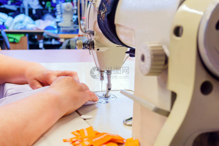 制衣厂的缝纫机和裁缝手掌上铺图片
