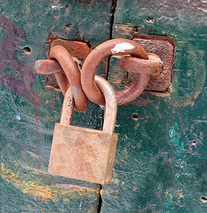 大型金属挂锁可安全关闭食品储藏室的绿色门图片