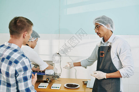 向客户展示雇员如何密封烤咖啡包的员工封图片