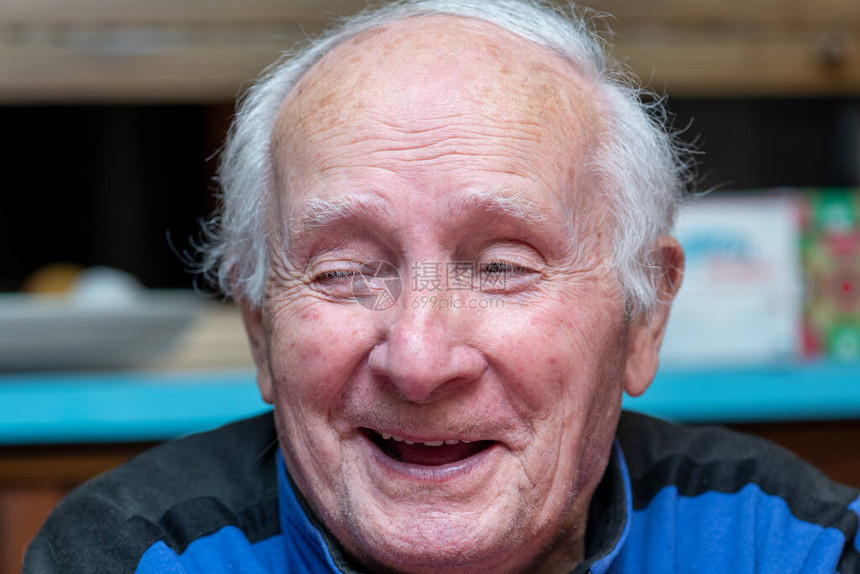 快乐的退休老人坐在家中笑着微笑幸福和退图片
