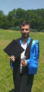 青年研究生在上拥有文凭和毕业证书垂直照片图片