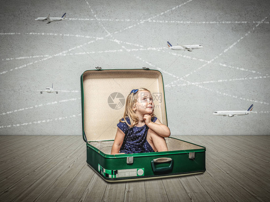 坐在一个旧行李箱里的小女孩想象着冒险和旅行的梦想图片