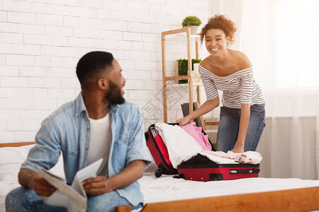 节日准备在家卧室的非裔美国人夫妇包装衣柜快乐选择焦点Focusive图片